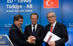 (From L) Turkish Prime Minister Ahmet Davutoglu, European Union Council President Donald Tusk and European Union Commission President Jean-Claude Juncker shake hands at the end of an European Union Summit held at the EU Council building in Brussels, on March 18, 2016. EU leaders and Turkey's prime minister approved a controversial deal to curb the huge flow of asylum seekers to Europe, with all migrants arriving in Greece from Sunday to be sent back. / AFP PHOTO / THIERRY CHARLIERTHIERRY CHARLIER/AFP/Getty Images